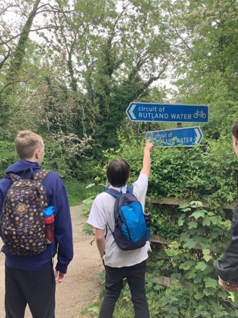 2 boys looking at signs on a footpath deciding which way to go during DoE event